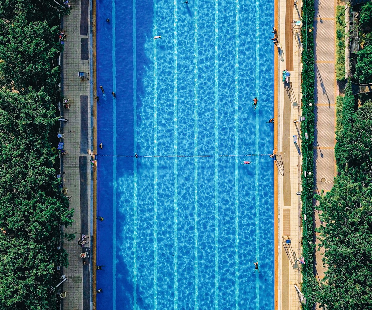 Sunlit turquoise swimming pool seen from above